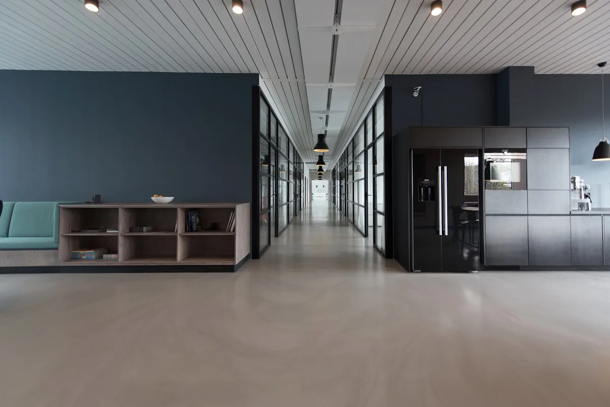 Open-plan office with rows of empty desks in the evening light, representing the quiet organizational cost that accumulates around a hiring decision gone wrong
